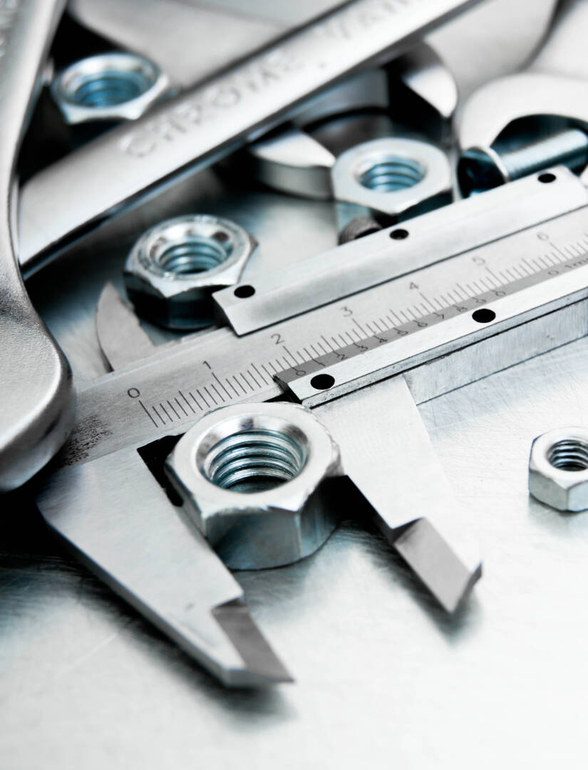 ?alliper and nuts on the scratched metal background.